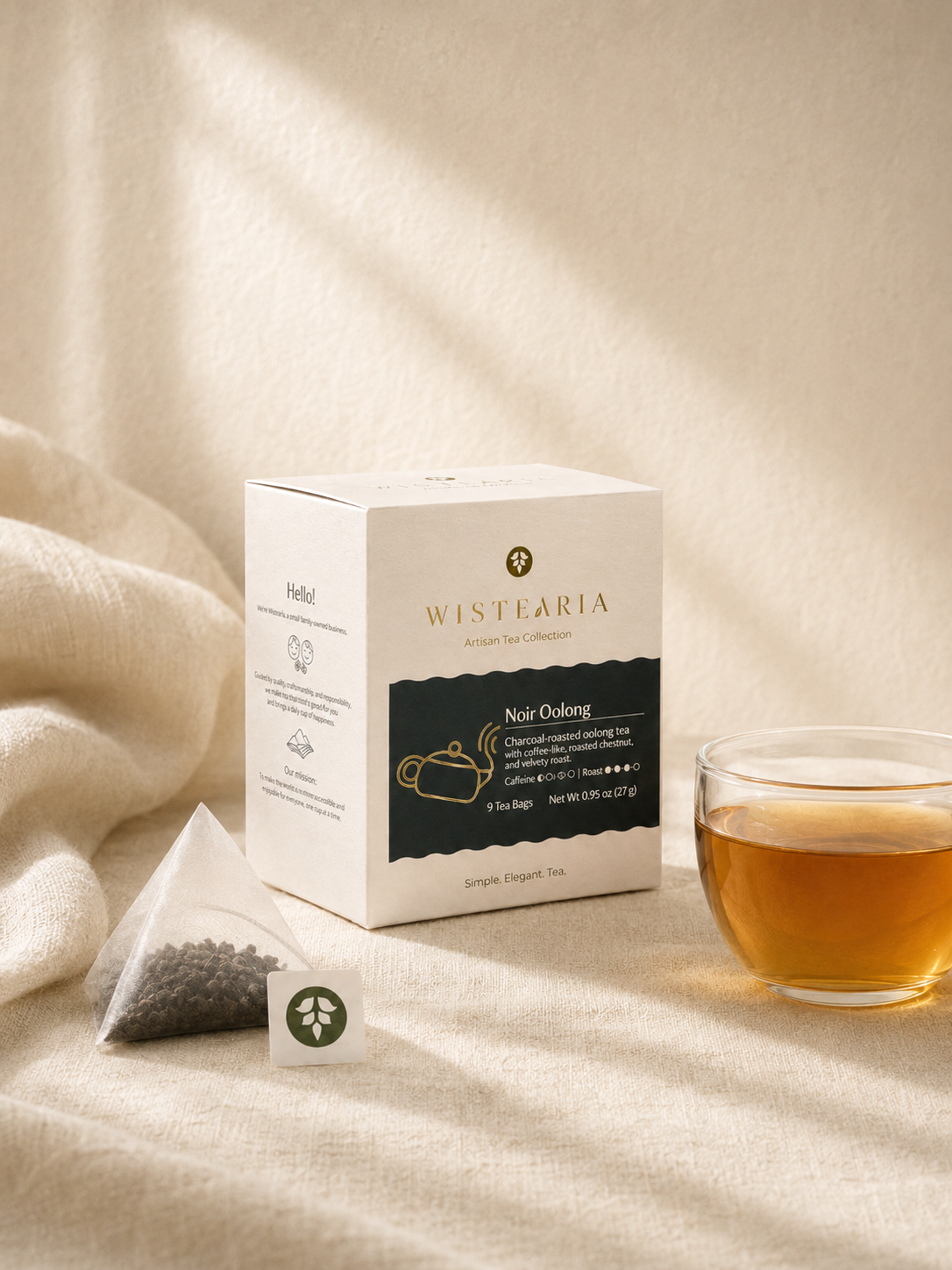 Noir Oolong tea sachet box, pyramid sachet, and glass cup of amber tea